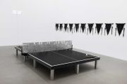<p>Yang Mushi, <em>Ping Pong - Beijing Moment</em>, 2024, aluminum, table tennis table, table tennis bat, table tennis, stainless steel, pennant (22 sides), digital clock, 31 x 180.5 x 1 cm (net), 64 x 264 x 188 cm (table), 57 x 43 x 3.5 (pennant), 15 x 44 x 2 cm (digital clock), installation size variable</p>
